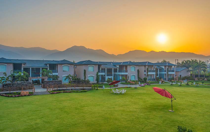 The resort lawn at golden hour with mountain backdrop